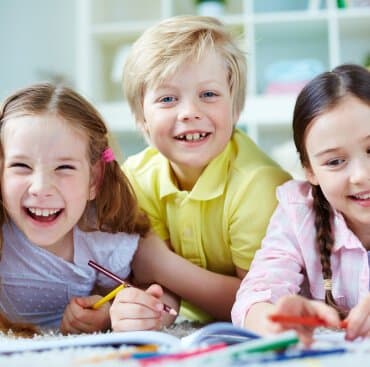Three children drawing on the floor together